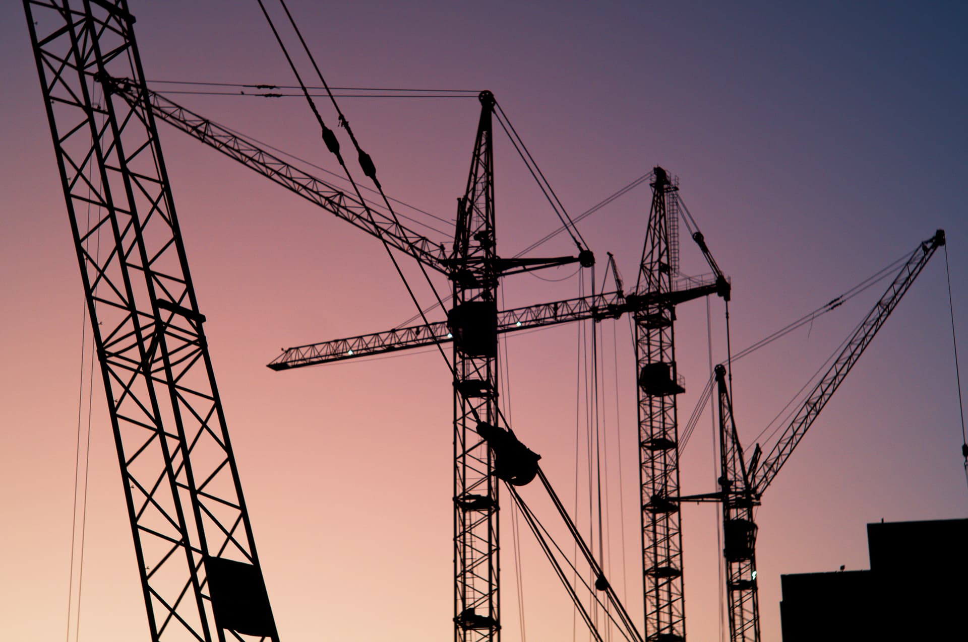 cranes against a sunset skyline