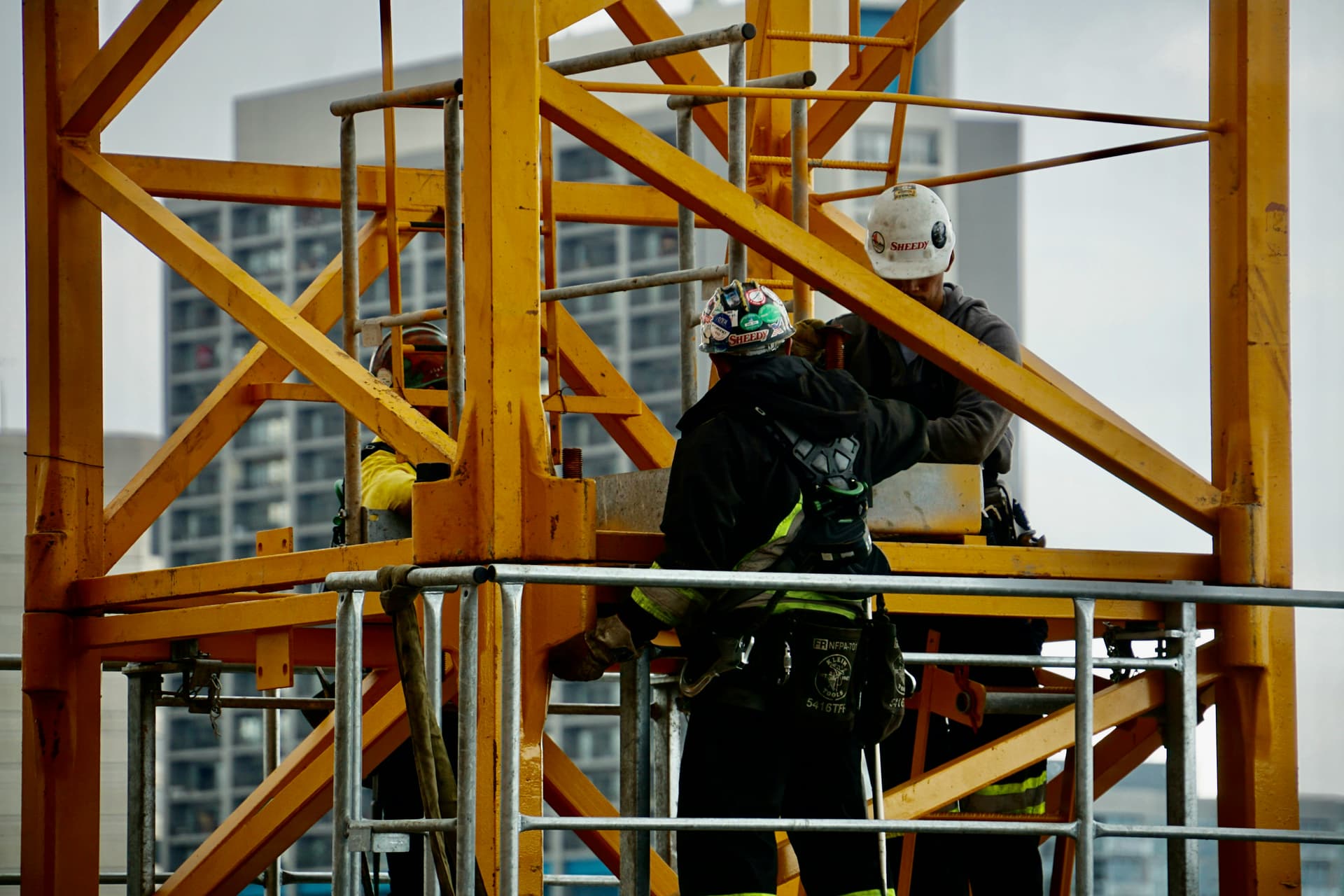 construction workers working on a crane with WAHR regulations in place